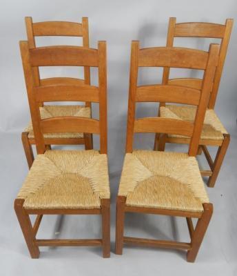 A set of four oak and rush seated ladderback dining chairs.