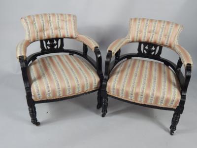 A pair of Victorian ebonised tub armchairs