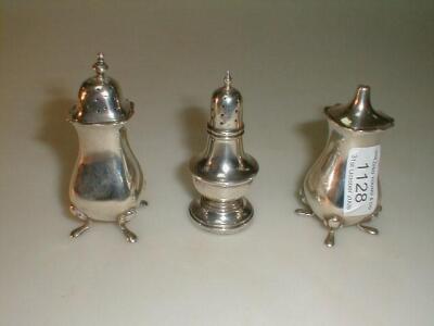 Two silver pepperettes and salt pot