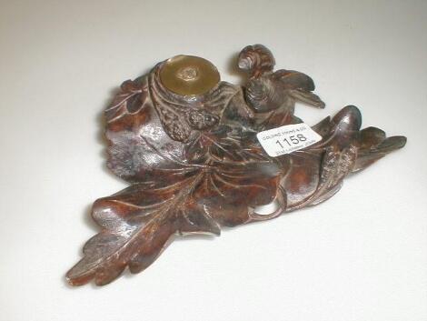 A 19thC Black Forest carved inkstand with later Luftwaffe brass well