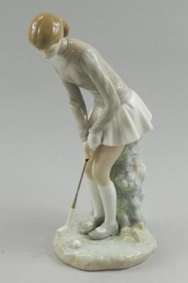 A Lladro porcelain figure modelled in the form of a female golfer