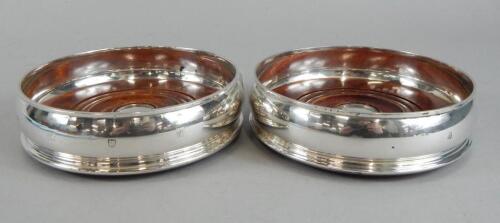 A pair of modern silver and mahogany wine coasters