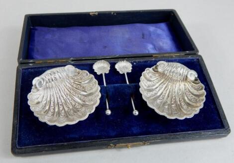 A pair of Edwardian silver shell shaped salts and spoons