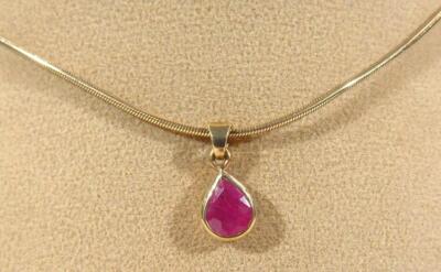 A pendant set with a pear shaped ruby