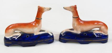 A pair of 19thC Staffordshire greyhound inkwell figures