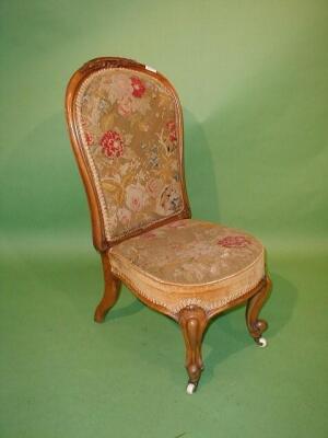 A Victorian walnut nursing chair with carved spoon back