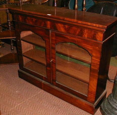 A 19thC flamed mahogany bookcase with a deep frieze and moulded top