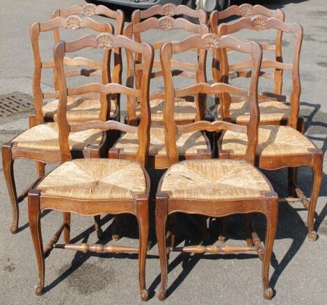 A set of eight early 20thC French oak ladder back dining chairs