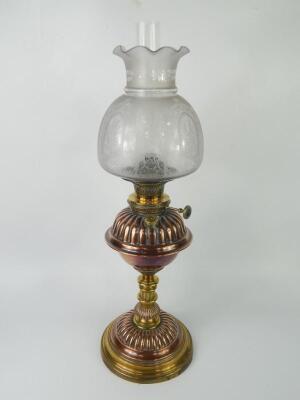 A Youngs copper and brass fluted oil lamp