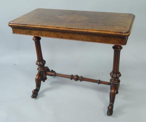 A Victorian walnut and boxwood inlaid fold over card table