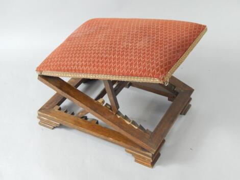 An early 20thC oak framed gout stool with upholstered seat