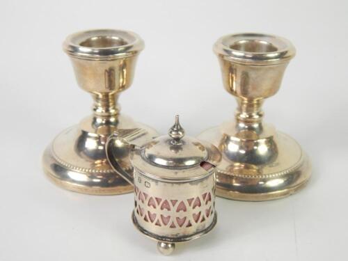 A pair of loaded silver squat candlesticks