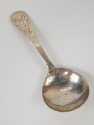 A Continental white metal spoon with floral engraved handle