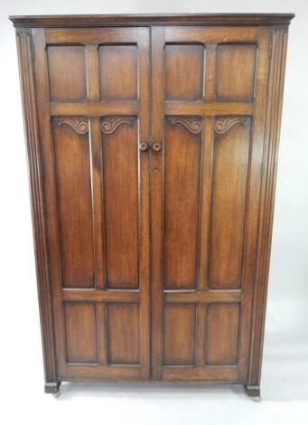 A Bobby & Co carved oak double wardrobe