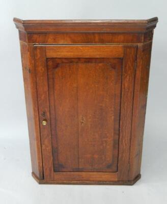 A George III oak and mahogany hanging corner cupboard