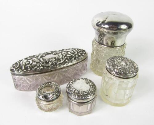 An Edwardian cut glass oval dressing table box with silver lid