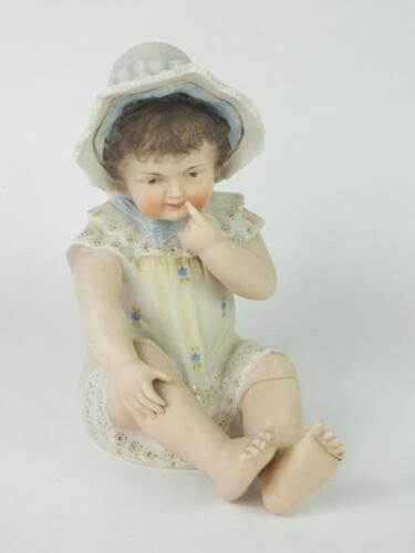 A Continental late 19thC bisque porcelain piano baby