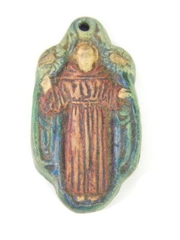 A Compton Pottery eary 20thC pottery pendant modelled as St Francis of Assisi.