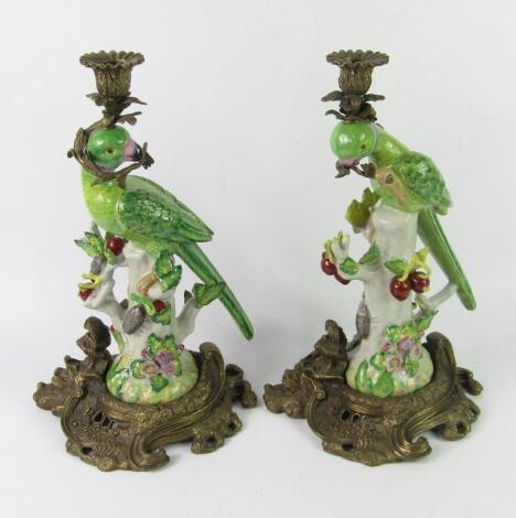 A pair of Continental porcelain and brass figures of parrots