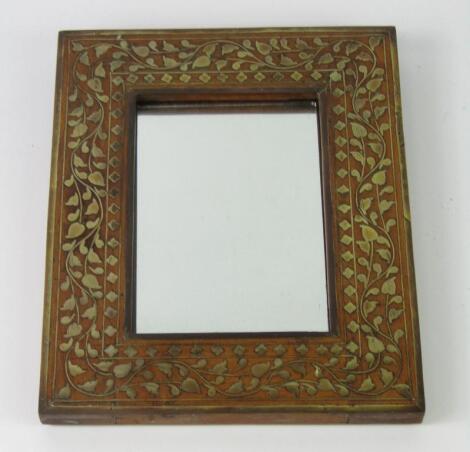 An Indian hardwood and damascene brass inlaid wall mirror