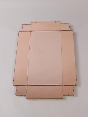 An Art Deco style pink glass sectional geometric wall mirror