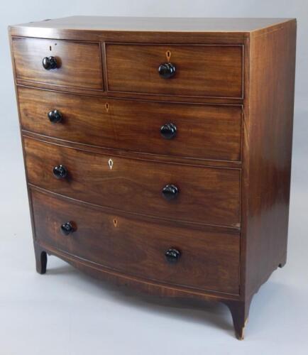 An early 19thC mahogany bow front chest of two short and three long cock beaded drawers
