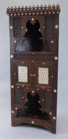 A late 19thC Middle Eastern hardwood and mother of pearl finish free standing corner cabinet