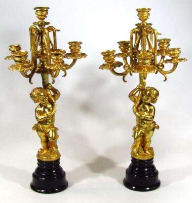 A pair of Regency style cast metal cherub garniture groups