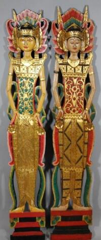 A near matching pair of modern painted pierced panels of Indian gods