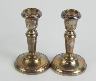 A pair of loaded silver candlesticks