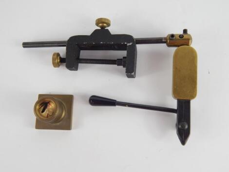 A brass and black painted metal fly tying clamp