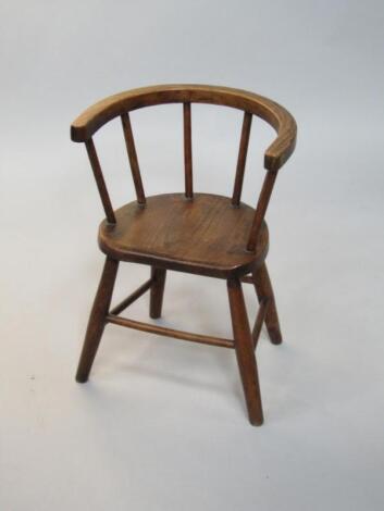 A 19thC oak and elm spindle back child's chair.