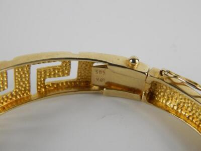 A yellow metal bangle in an open work Greek Key design - 2