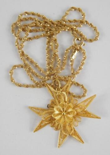 A yellow metal filigree Maltese cross pendant