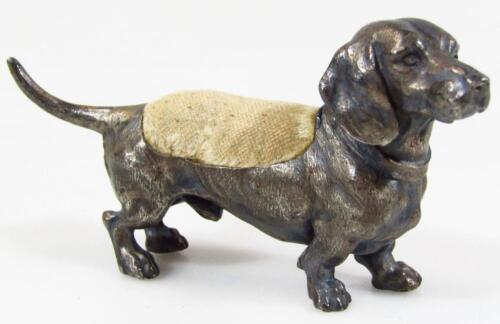 A cold painted metal dachshund dog pin cushion