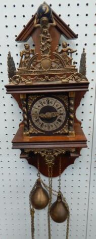 A reproduction brass and mahogany wall clock