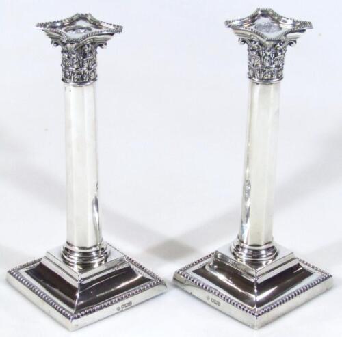 A pair of Edwardian silver Corinthian column candlesticks