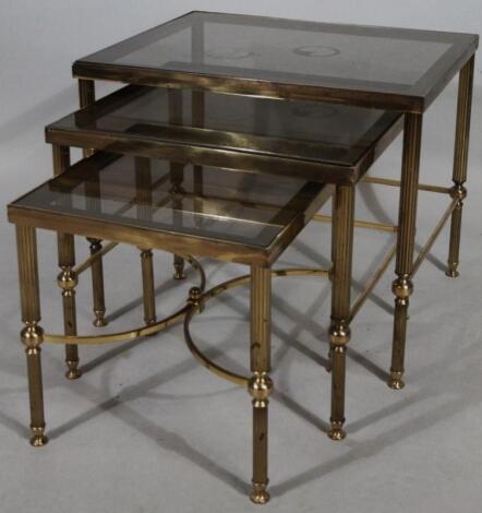 A nest of modern metal framed and smoke glass coffee tables