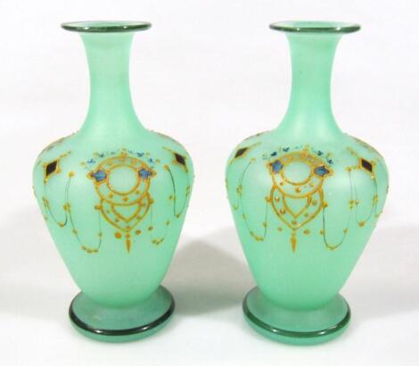 A pair of Edwardian green glass vases