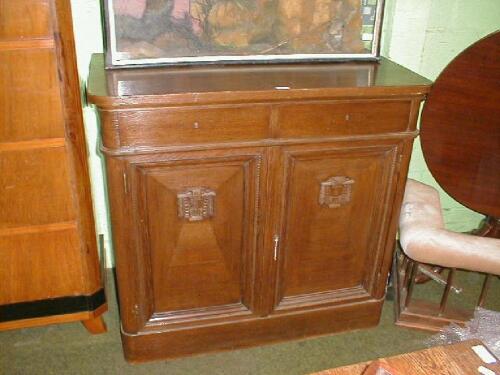 A continental oak side cabinet with two doors over two drawers