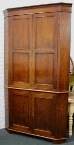 An early 19thC oak standing corner cabinet