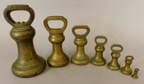 Seven Victorian graduated brass bell weights.