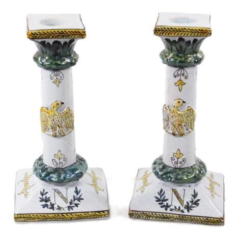 A pair of 19thC faience tin glazed earthenware pottery Napoleonic candlesticks