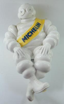 A Michelin Man plaster seated advertising figures