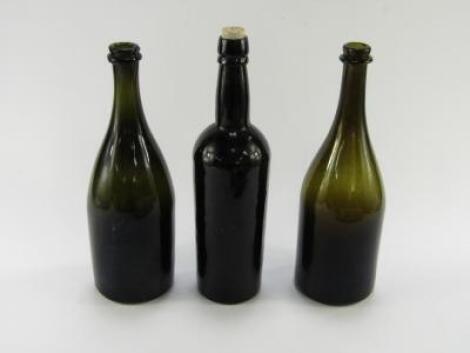 A pair of 18thC green glass wine bottles