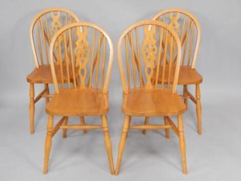 A set of four Radonstro beech and oak wheel back single kitchen chairs.