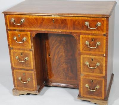 A George III mahogany and satinwood kneehole desk