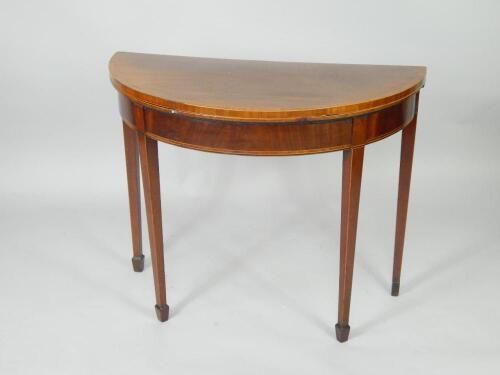 A George III mahogany demi lune fold over card table