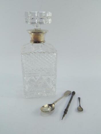 A cut glass decanter with a silver collar