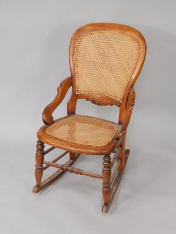 A Victorian balloon back rocking chair with cane seat and back